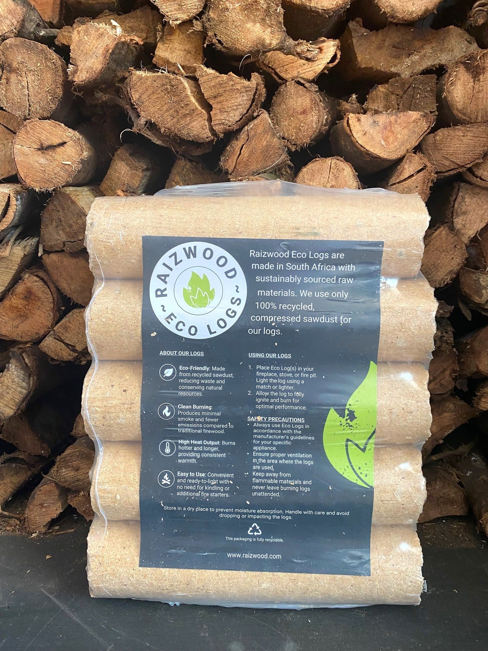 A pack of Raizwood Eco Logs in front of a stack of firewood